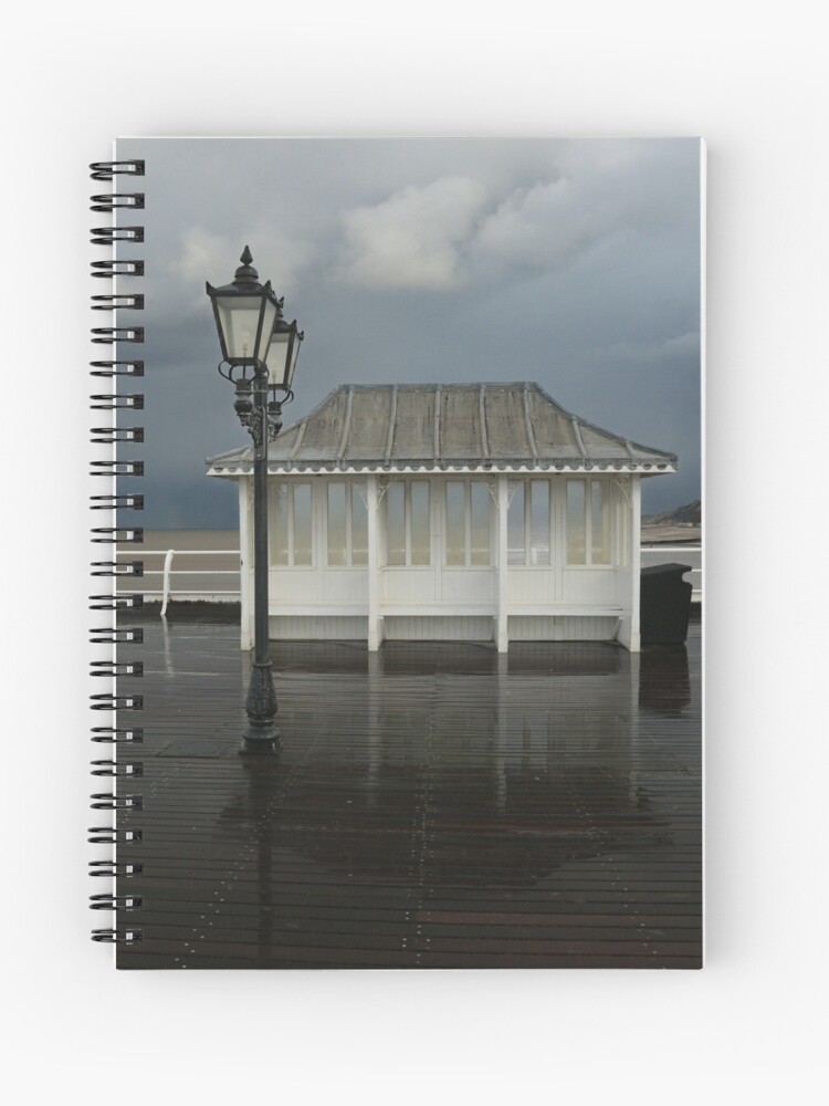 Cromer Pier - shelter in a storm spiral notebook. Cover image by MyriadLifePhoto. Lined or graph paper pages available. Please visit the image link to buy from Redbubble.com